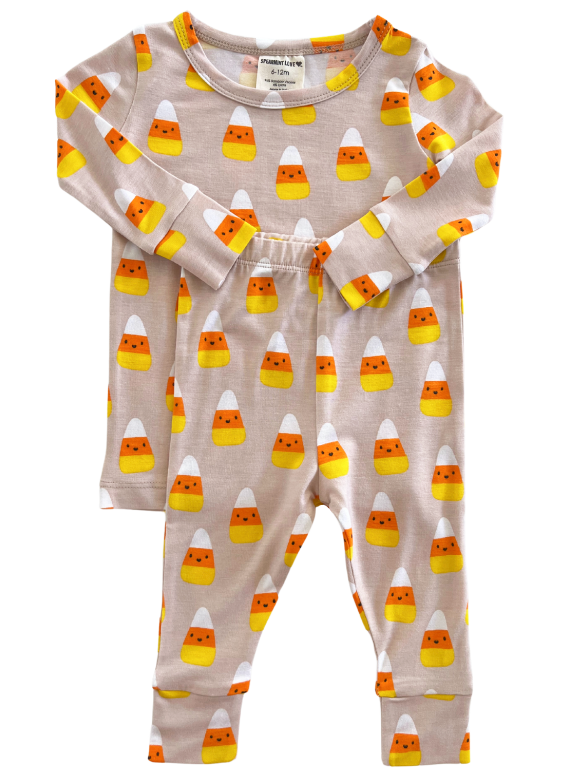 Children's pajamas with a candy corn pattern in yellow, orange, and white on a light beige background.