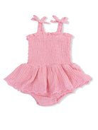 Pink baby romper with straps and ruffled skirt, featuring embroidered details at the hem. Ideal for warm weather.