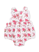 White floral romper with pink roses and green leaves, featuring cross-back straps and ruffled detailing.