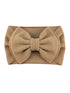 Tan headband with a large bow design, made from textured fabric. Perfect for adding a stylish touch.