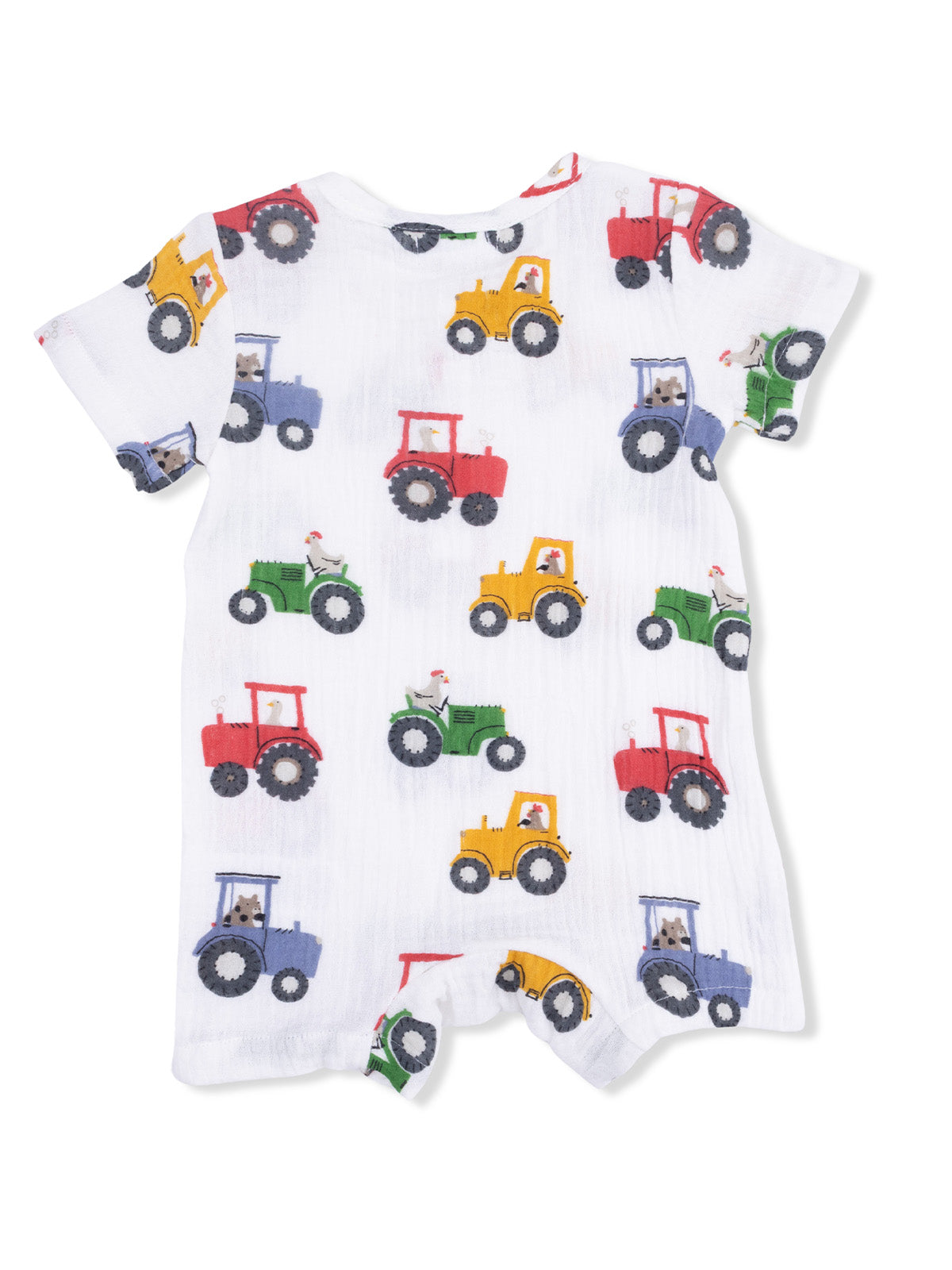 White baby romper with colorful tractor patterns in red, blue, yellow, and green on a soft background.
