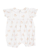 White baby romper with playful rocking horse print and ruffled sleeves, featuring a Peter Pan collar.