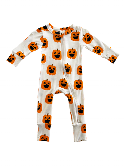 White onesie with pumpkin print in orange and black, featuring a front zipper and long sleeves. Perfect for Halloween!