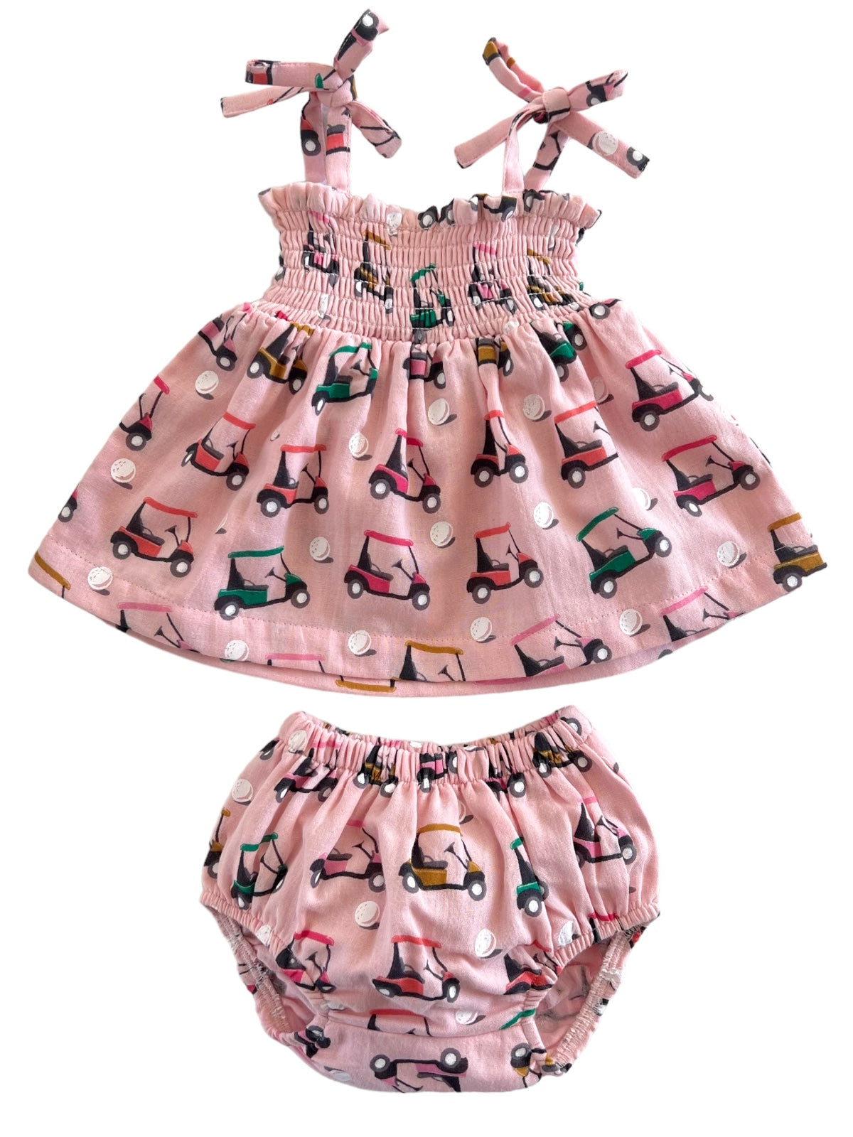 Pink children's outfit featuring a smocked top and matching bloomer, decorated with colorful golf cart patterns.