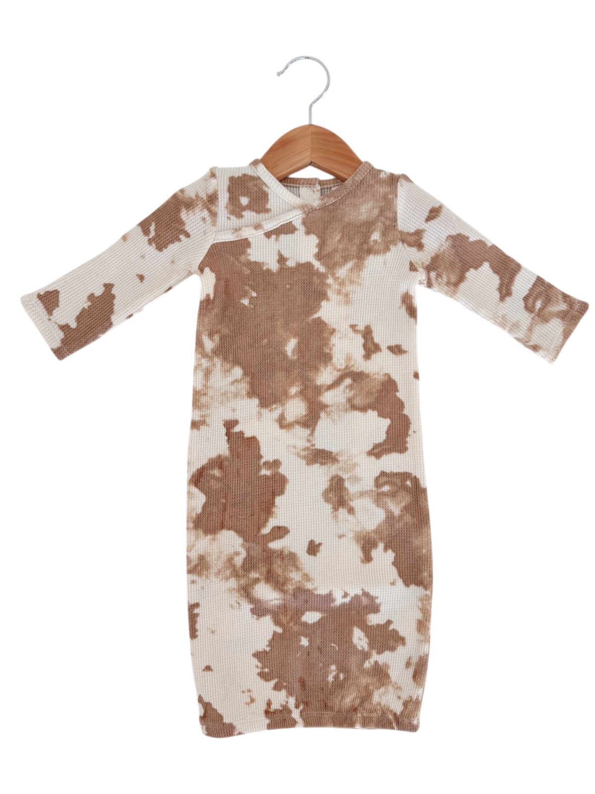 Brown and cream tie-dye dress on a hanger with long sleeves and round neckline.