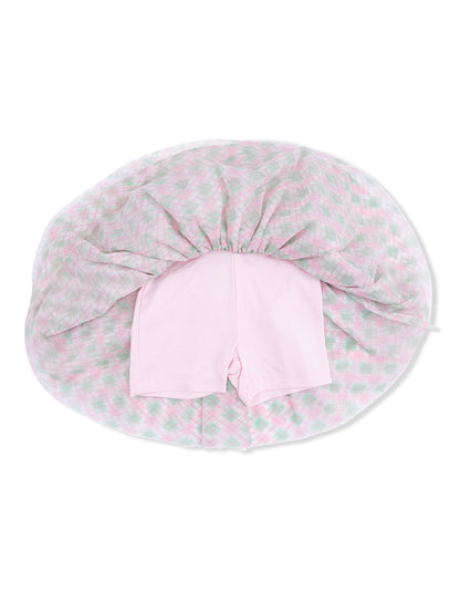 Pink shorts lying on top of a pastel plaid blanket, viewed from above.
