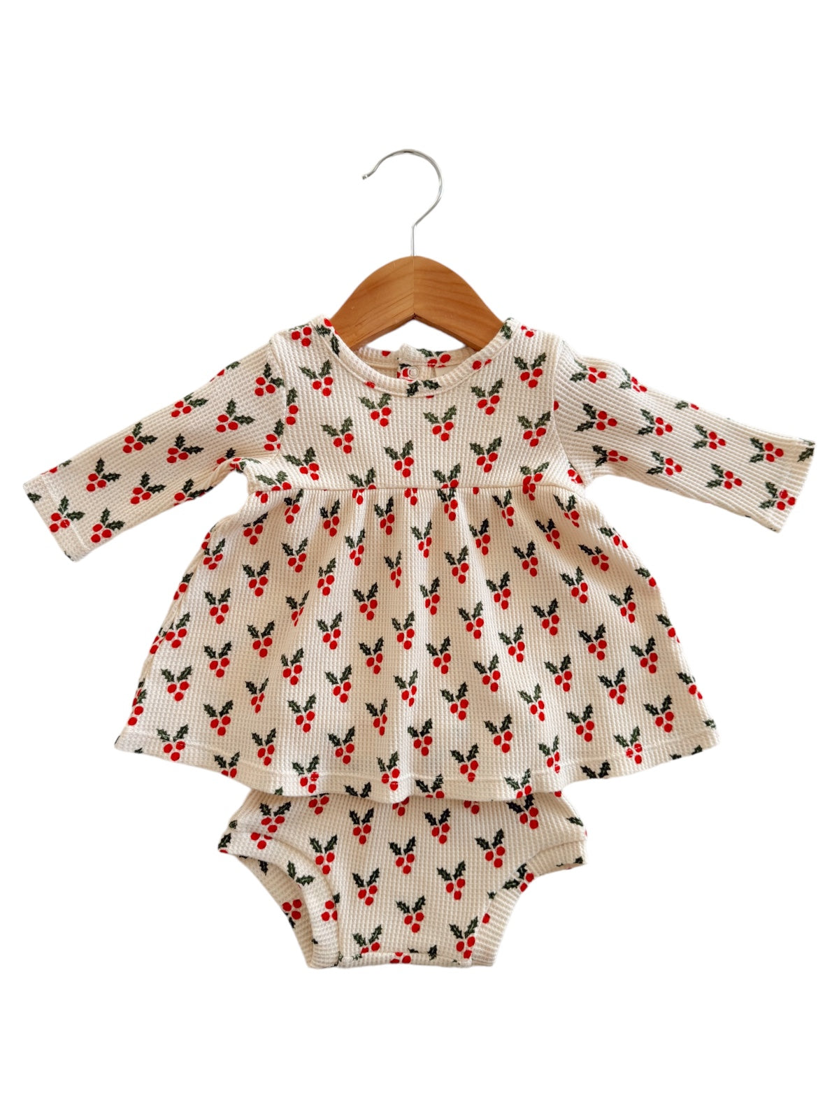 Patterned baby dress with long sleeves and matching bloomers, featuring red berries on a cream background.