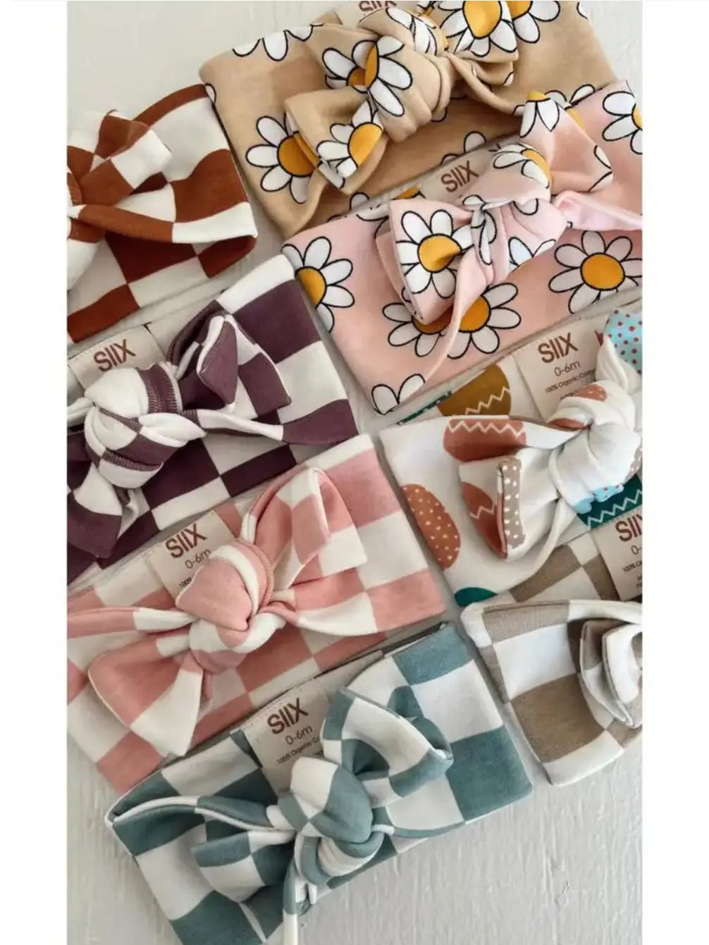Colorful baby headbands with bows, featuring various patterns and designs, displayed neatly together.