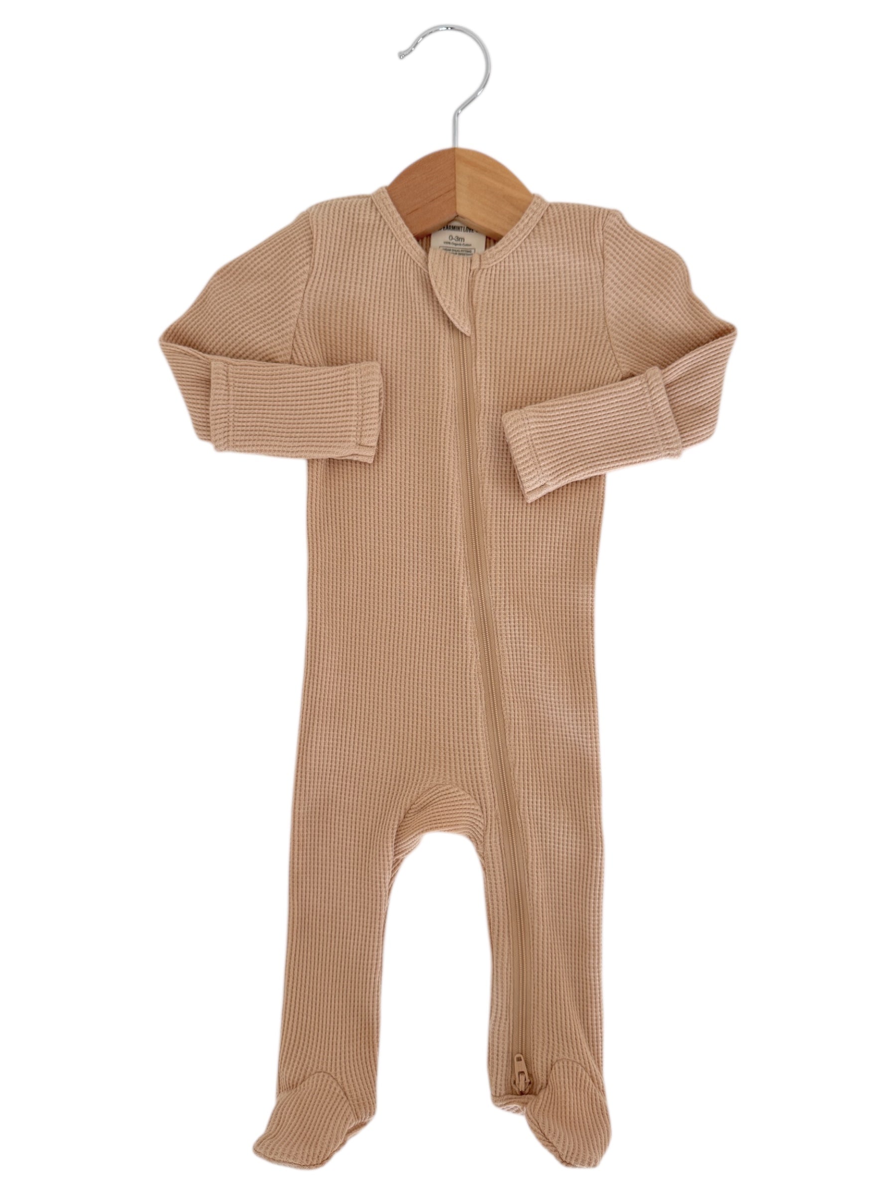 Light beige baby onesie with a zipper, displayed on a wooden hanger.
