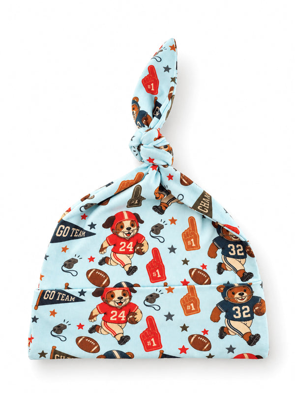 Blue baby hat with playful bear illustrations in sports gear and themed decorations like footballs and stars.