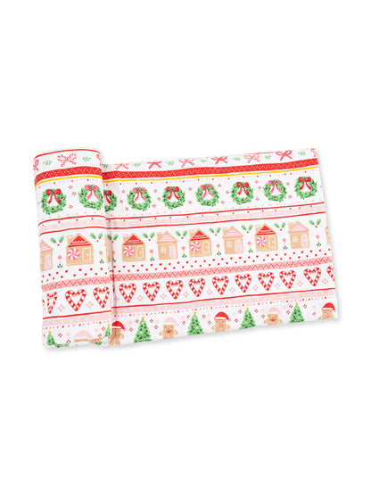 Festive wrapping paper featuring gingerbread houses, wreaths, and holiday motifs in red and green colors.