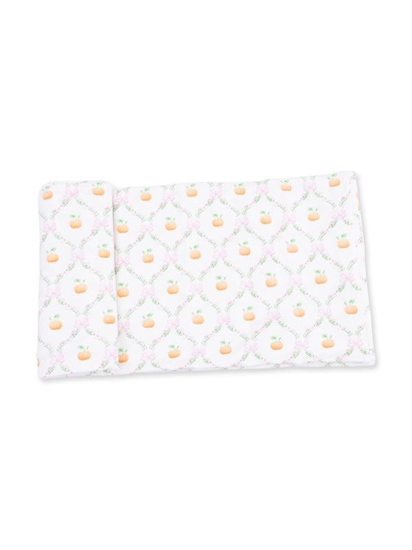 Patterned fabric featuring small pumpkins and floral designs on a white background.