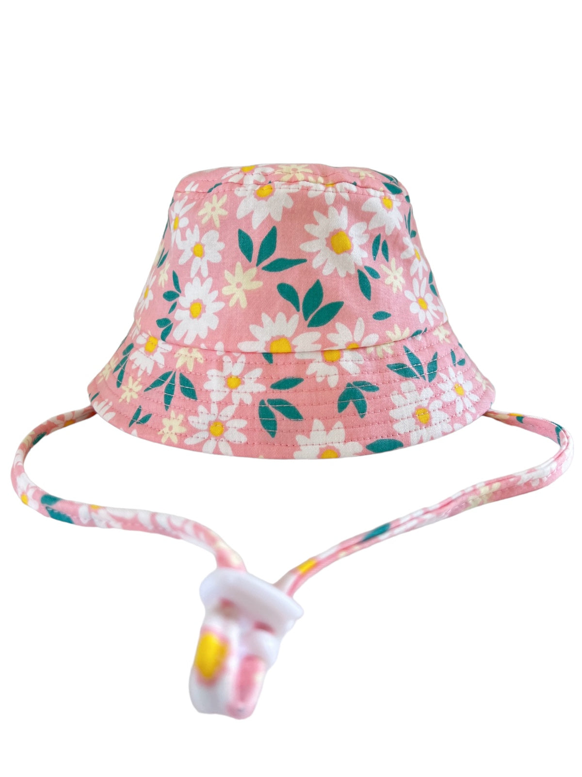 Pink bucket hat with white daisies and green leaves, featuring a matching adjustable chin strap.