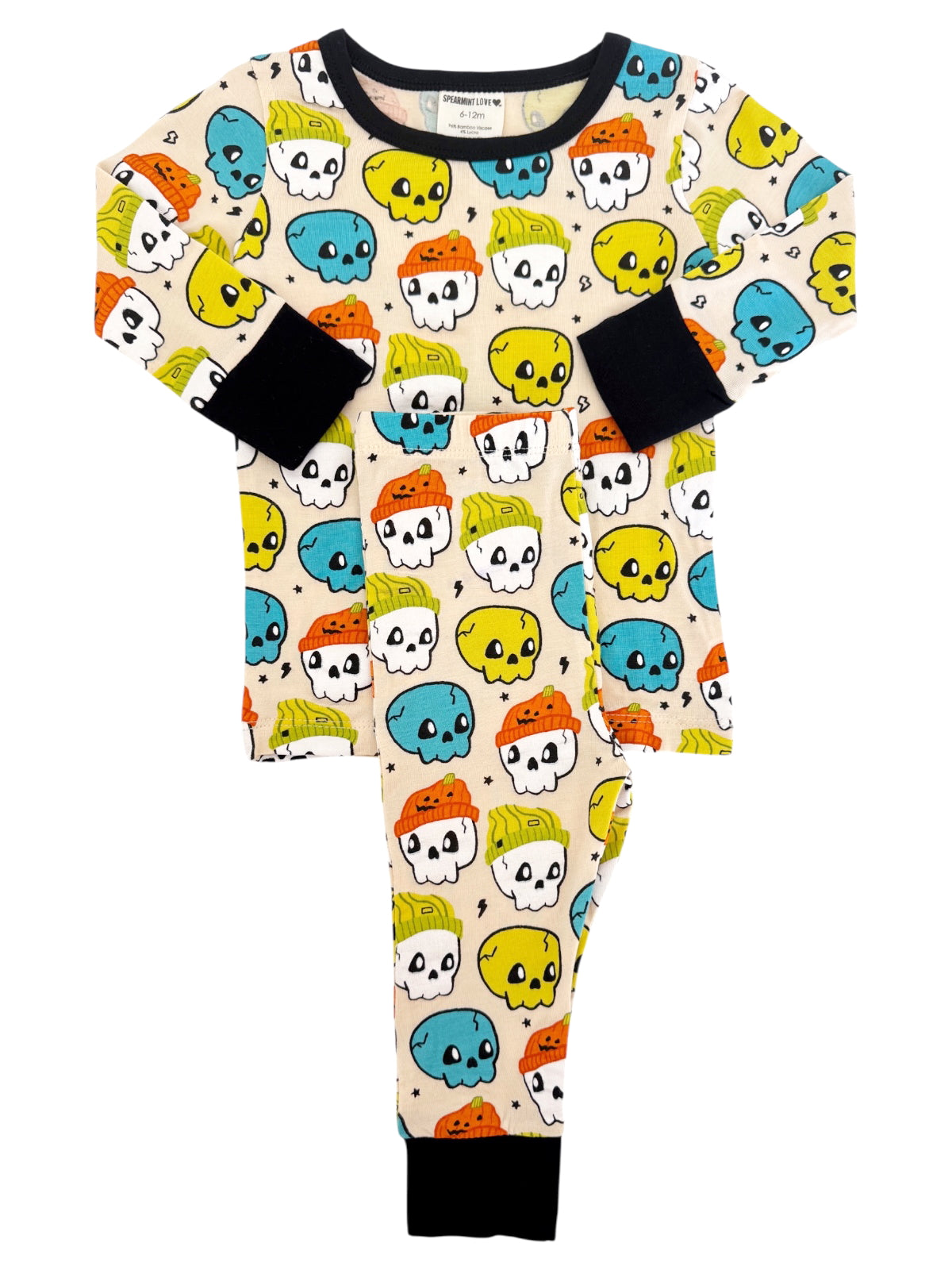 Kids' pajamas featuring colorful skull patterns in blue, yellow, orange, and green on a cream background.