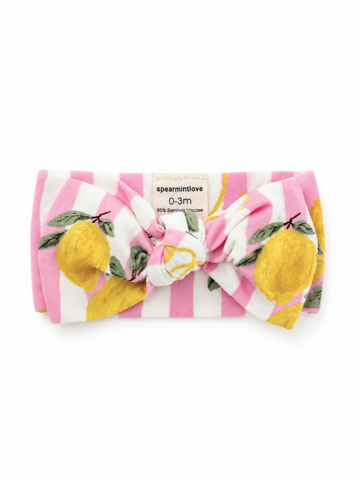 Pink striped baby headband with lemon print, featuring a large bow, labeled "spear mint love." For ages 0-3 months.