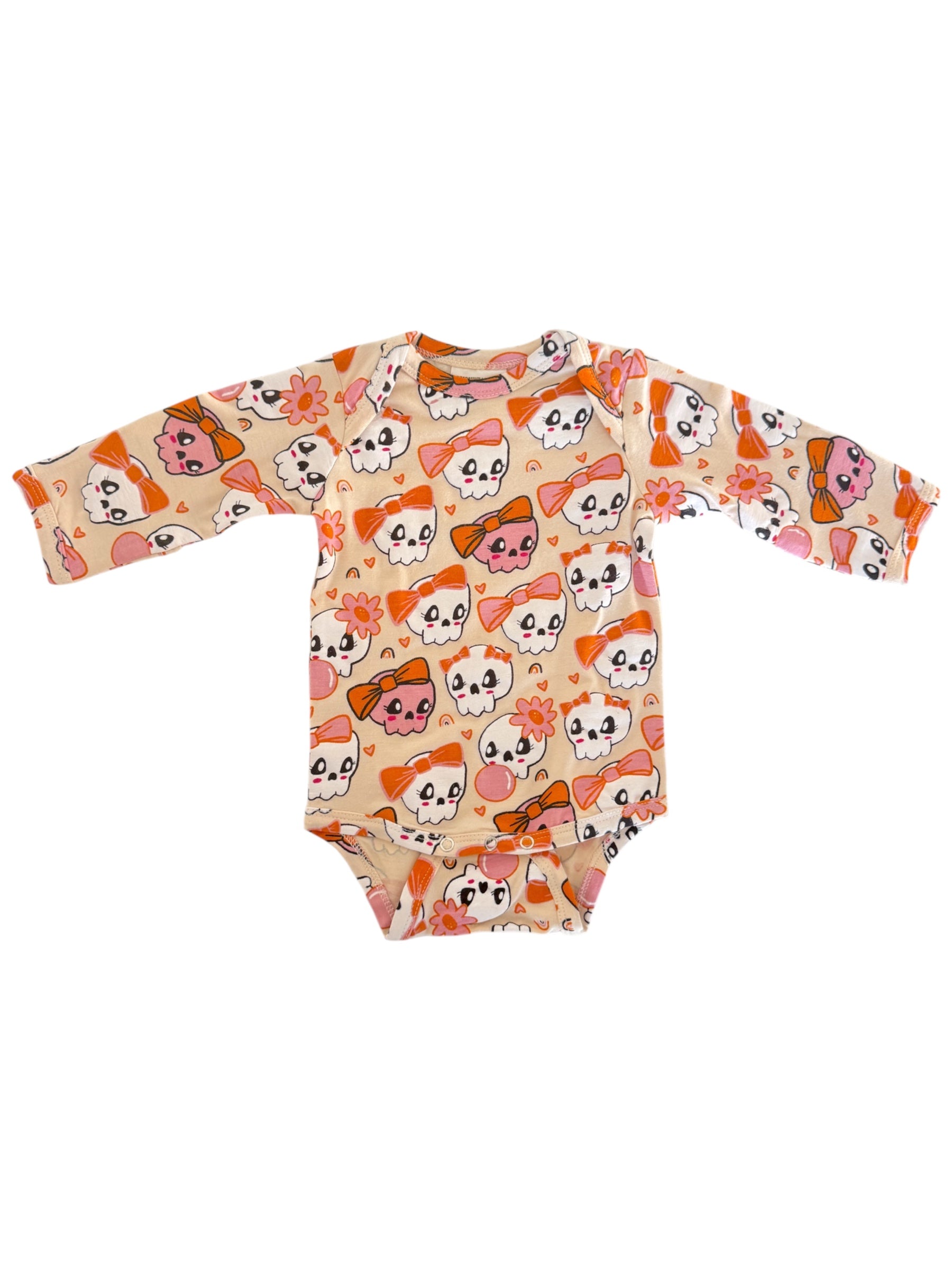 Baby bodysuit with colorful skull and flower patterns on a light background. Long sleeves and snap closure at the bottom.