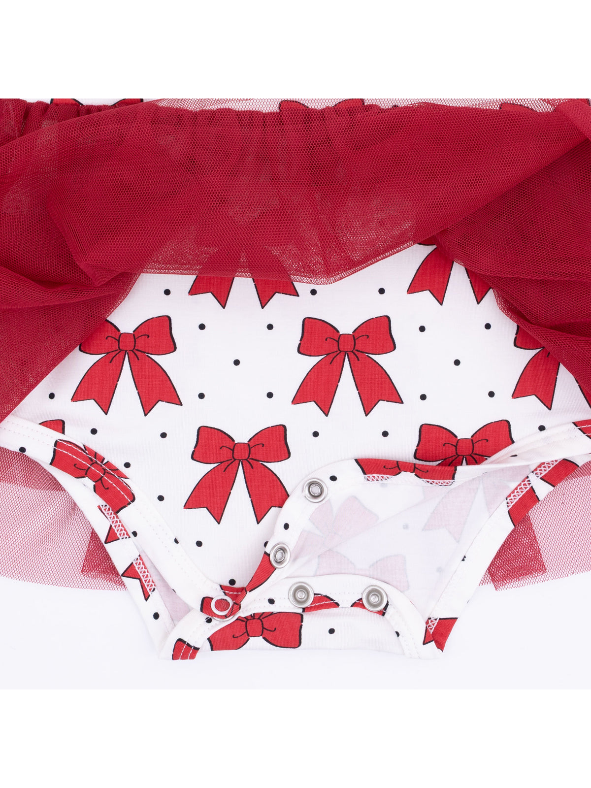 Red bow-patterned fabric with a tulle overlay, showcasing snap closures at the bottom. Suitable for children's wear.