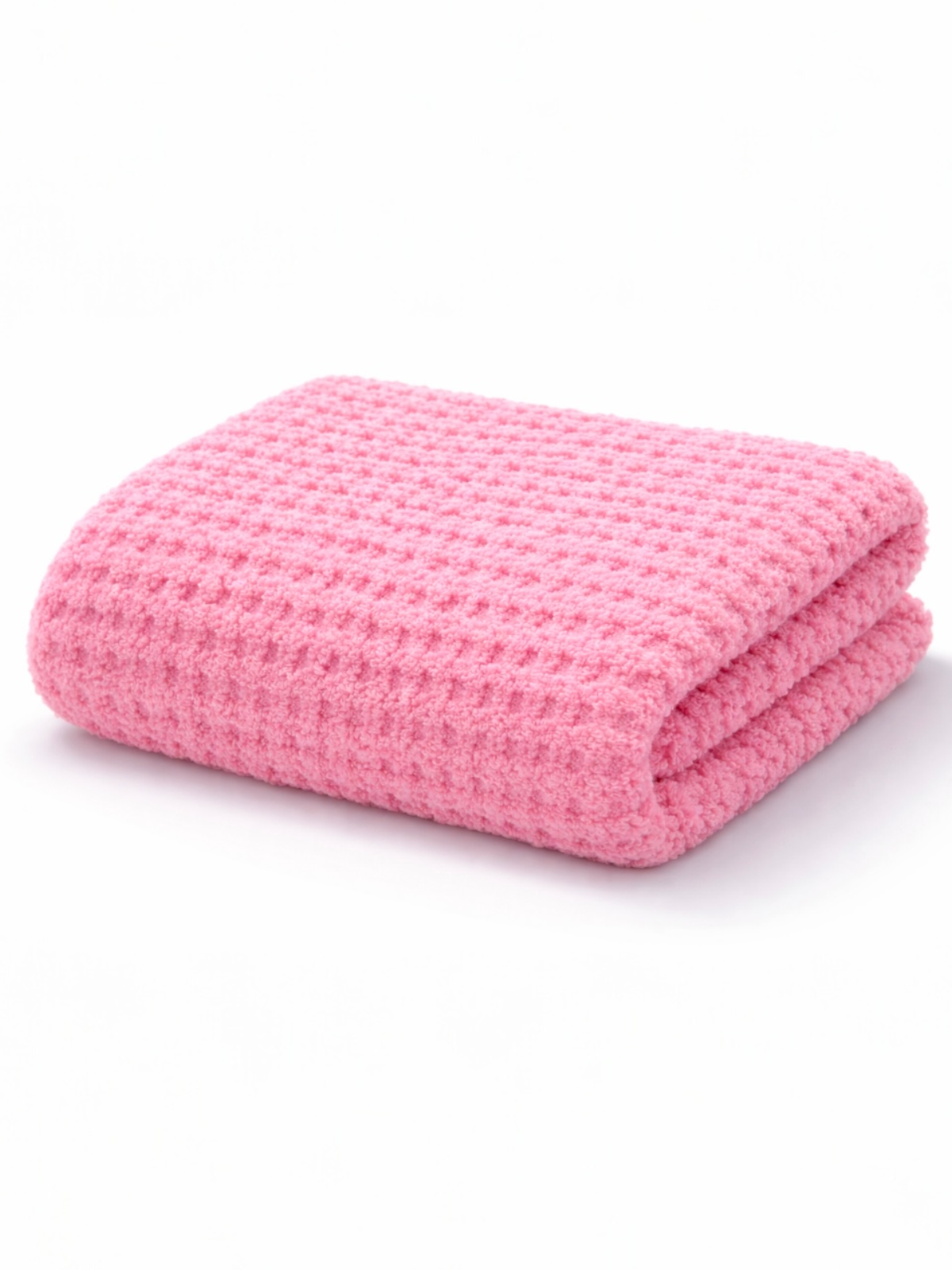 Folded pink textured blanket with a soft, cozy appearance on a white background.