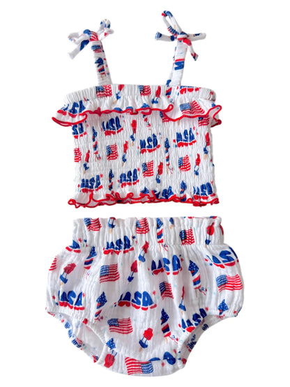 Baby girl's two-piece outfit featuring white fabric with red and blue patterns of flags and "NASA" print.