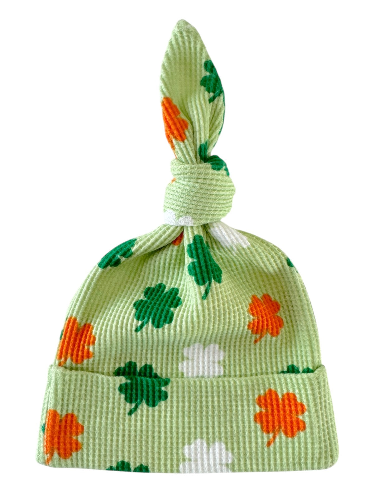 Green hat with shamrock patterns in orange, green, and white, featuring a knotted top.