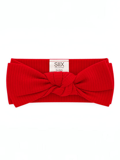Red ribbed headband with a large knot, suitable for infants aged 0-6 months.