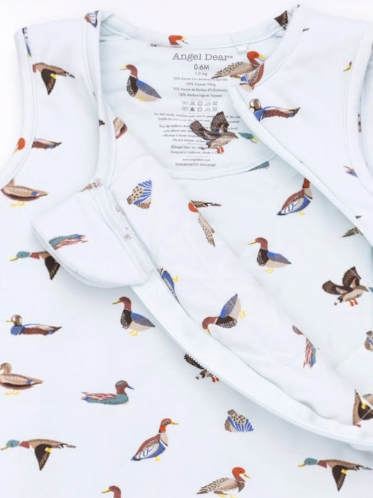 Light blue fabric with duck patterns, featuring a label for Angel Dear, size 0-6 months.