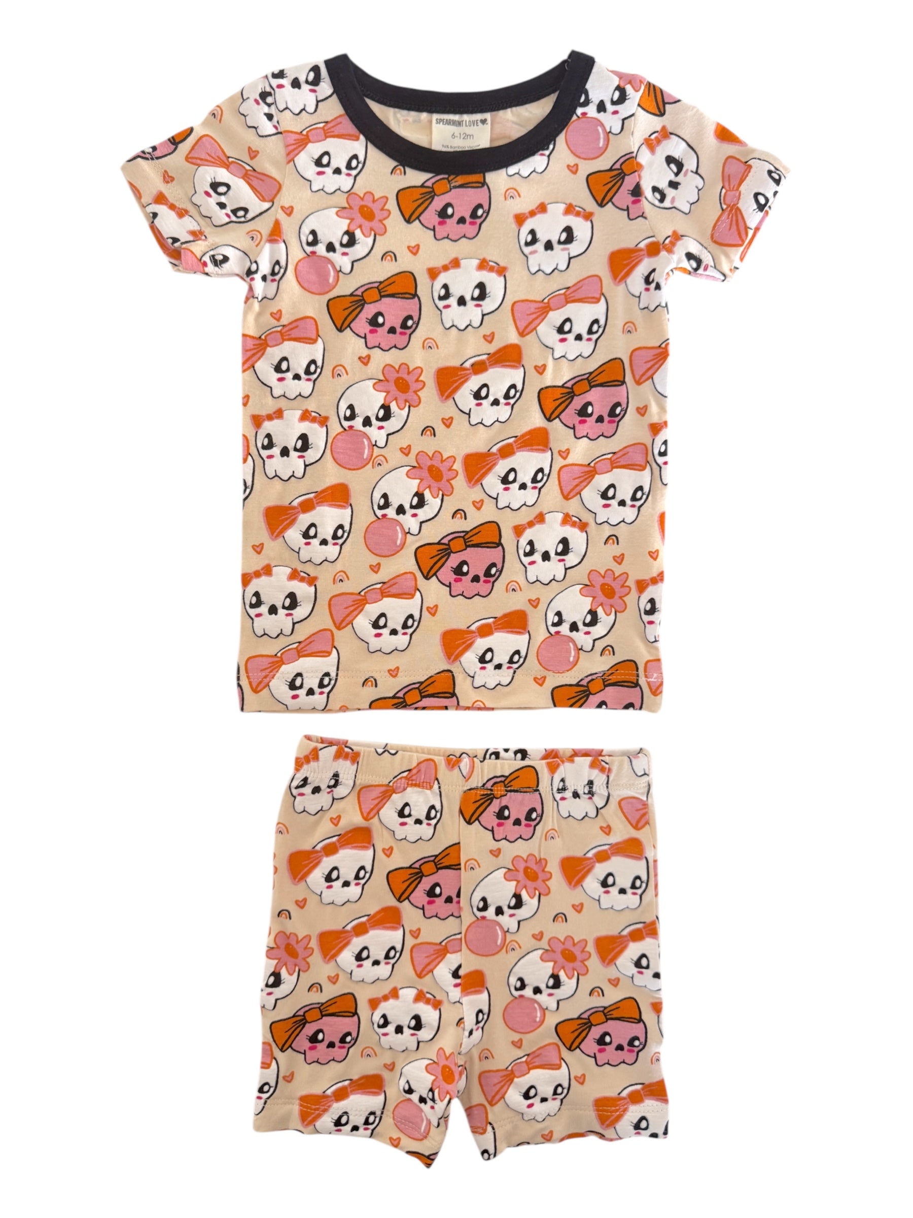 Kids' pajamas set featuring playful skull and bow patterns in bright colors, ideal for sleepwear or lounging.