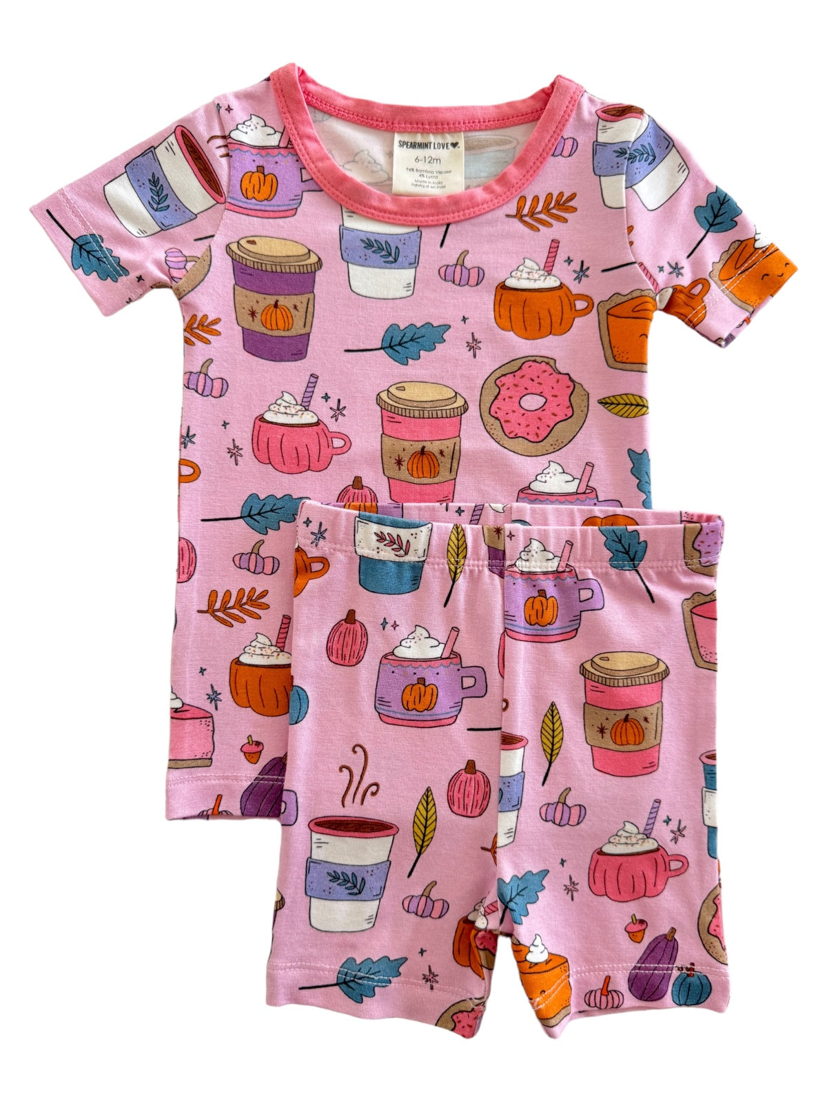 Pink children’s pajamas featuring playful patterns of beverages, pumpkins, and donuts.