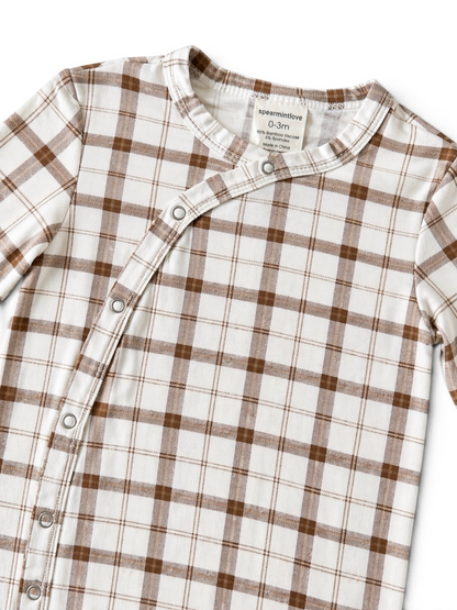 White and brown plaid infant onesie with snap buttons, labeled size 0-3 months.