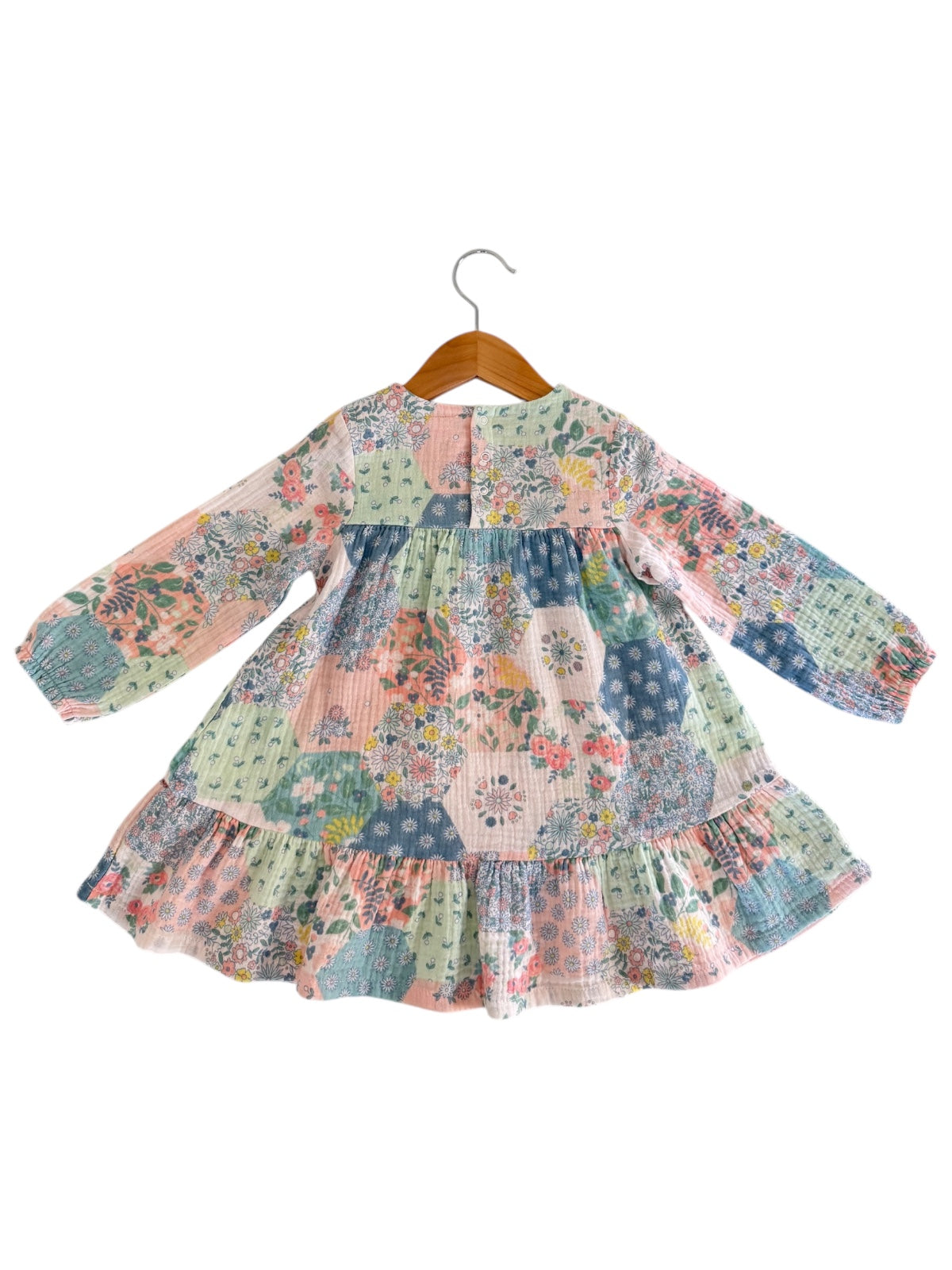 Long-sleeve floral dress on a hanger, featuring a colorful patchwork design with ruffled hem.