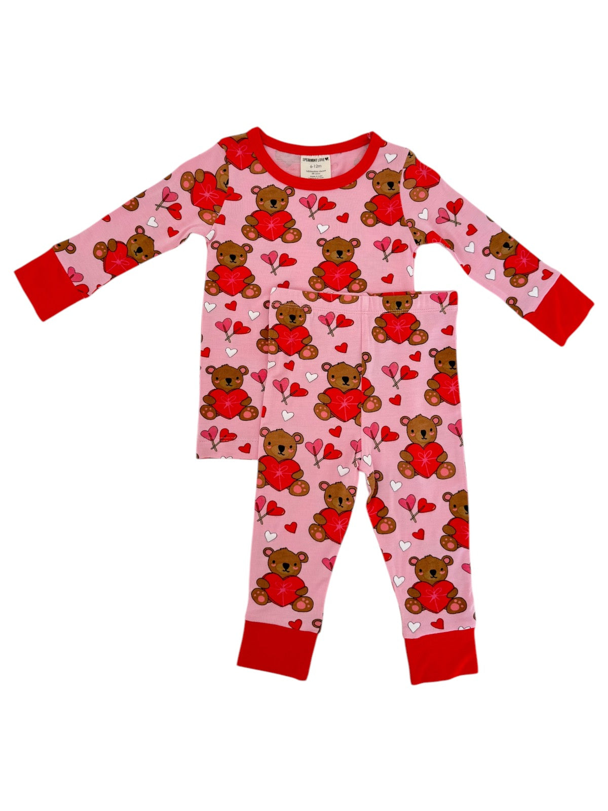 Pink children's pajamas with teddy bears, hearts, and arrows, featuring long sleeves and red accents.