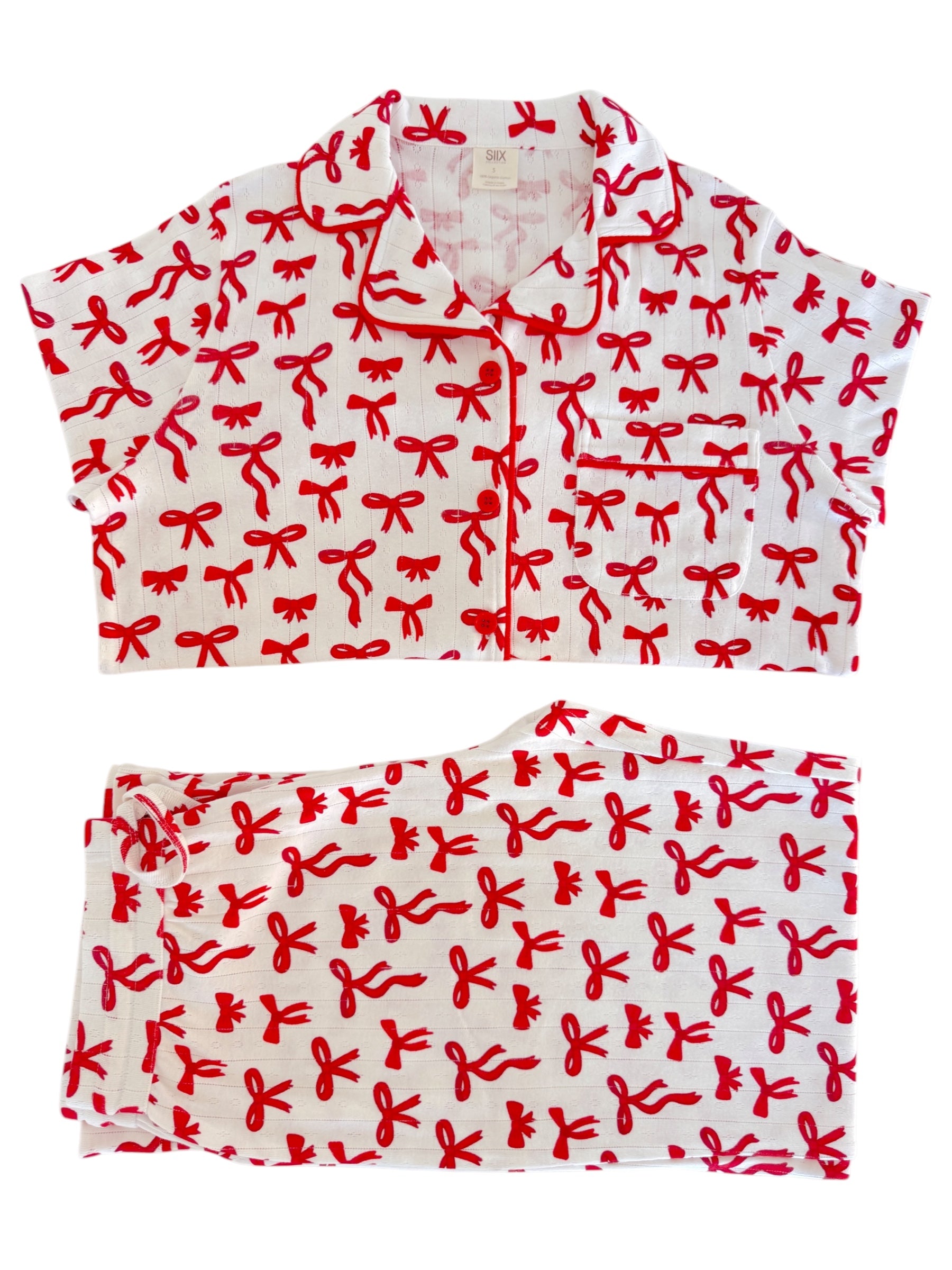 Red bow-patterned pajama set featuring a short-sleeve top and matching pants on a white background.