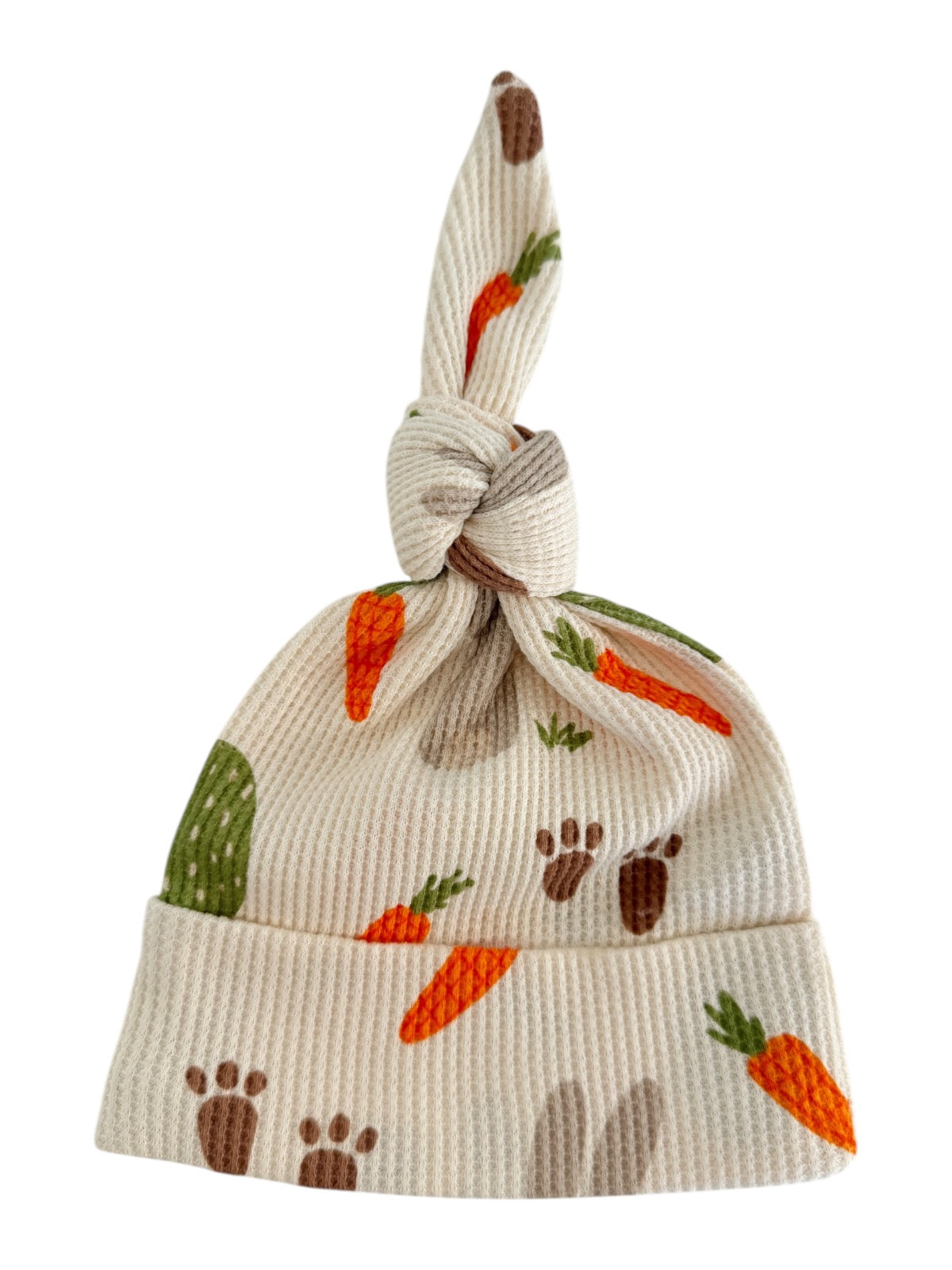 Knotted baby hat with carrot and paw print patterns on a soft, ribbed fabric.
