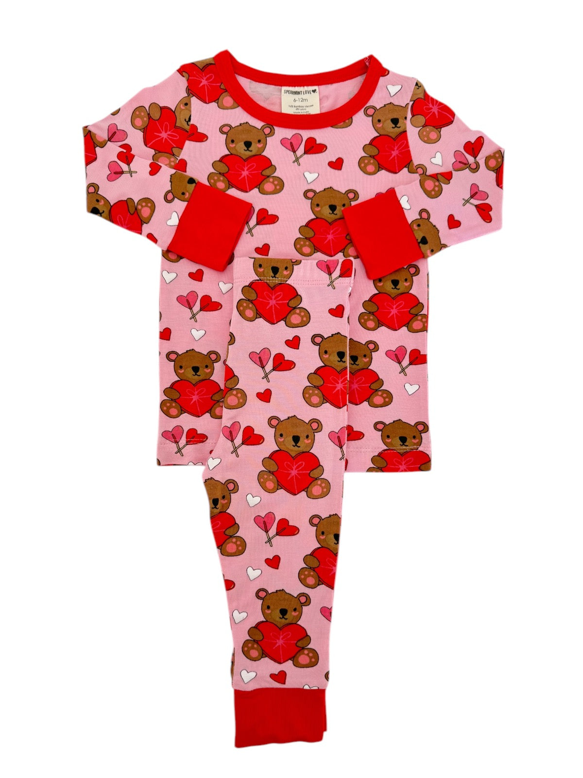Pink pajamas with teddy bears and hearts, featuring red accents and long sleeves. Perfect for kids’ cozy wear.
