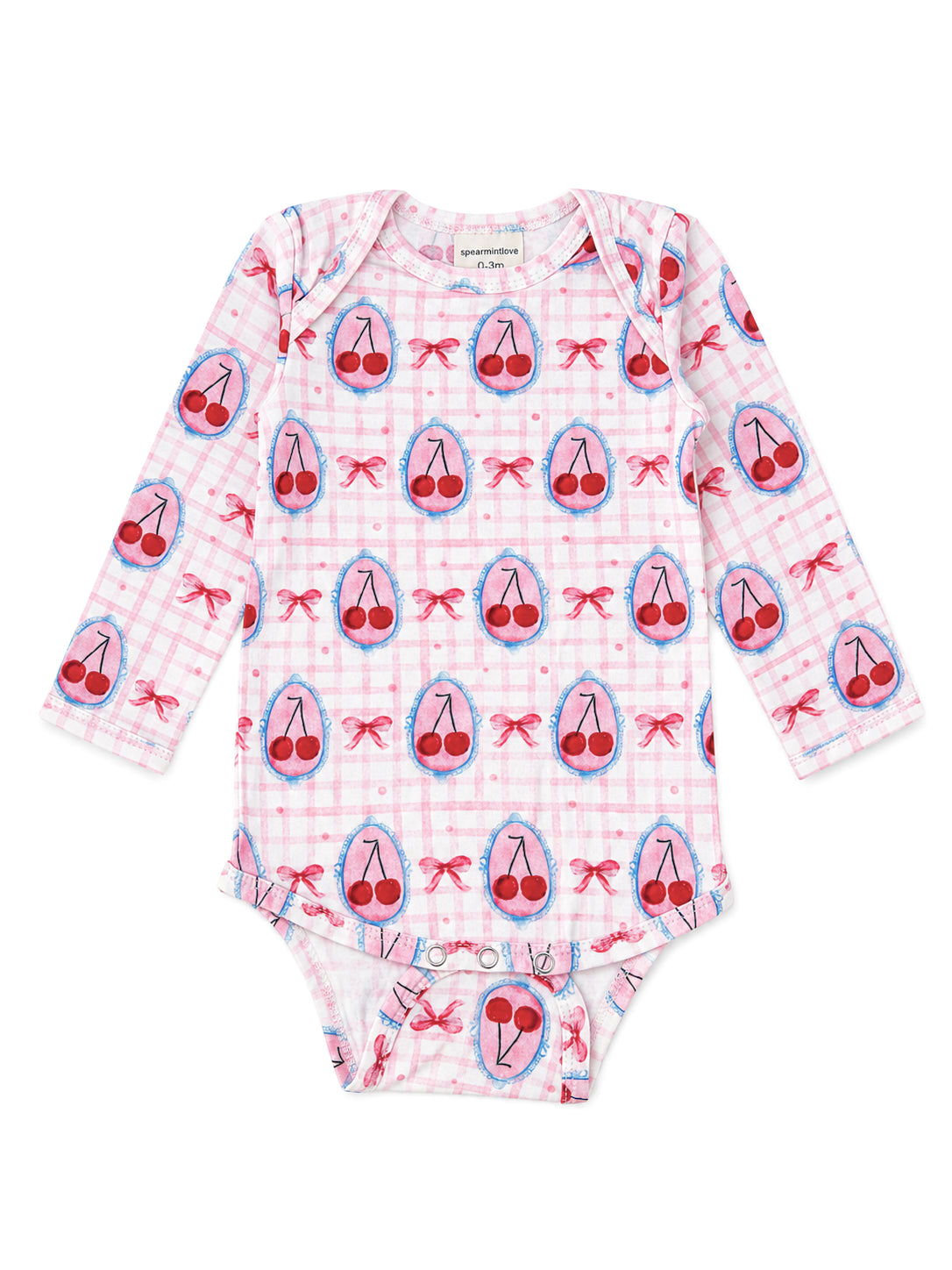 Pink long-sleeve baby onesie with cherry and bow patterns on a checkered background.