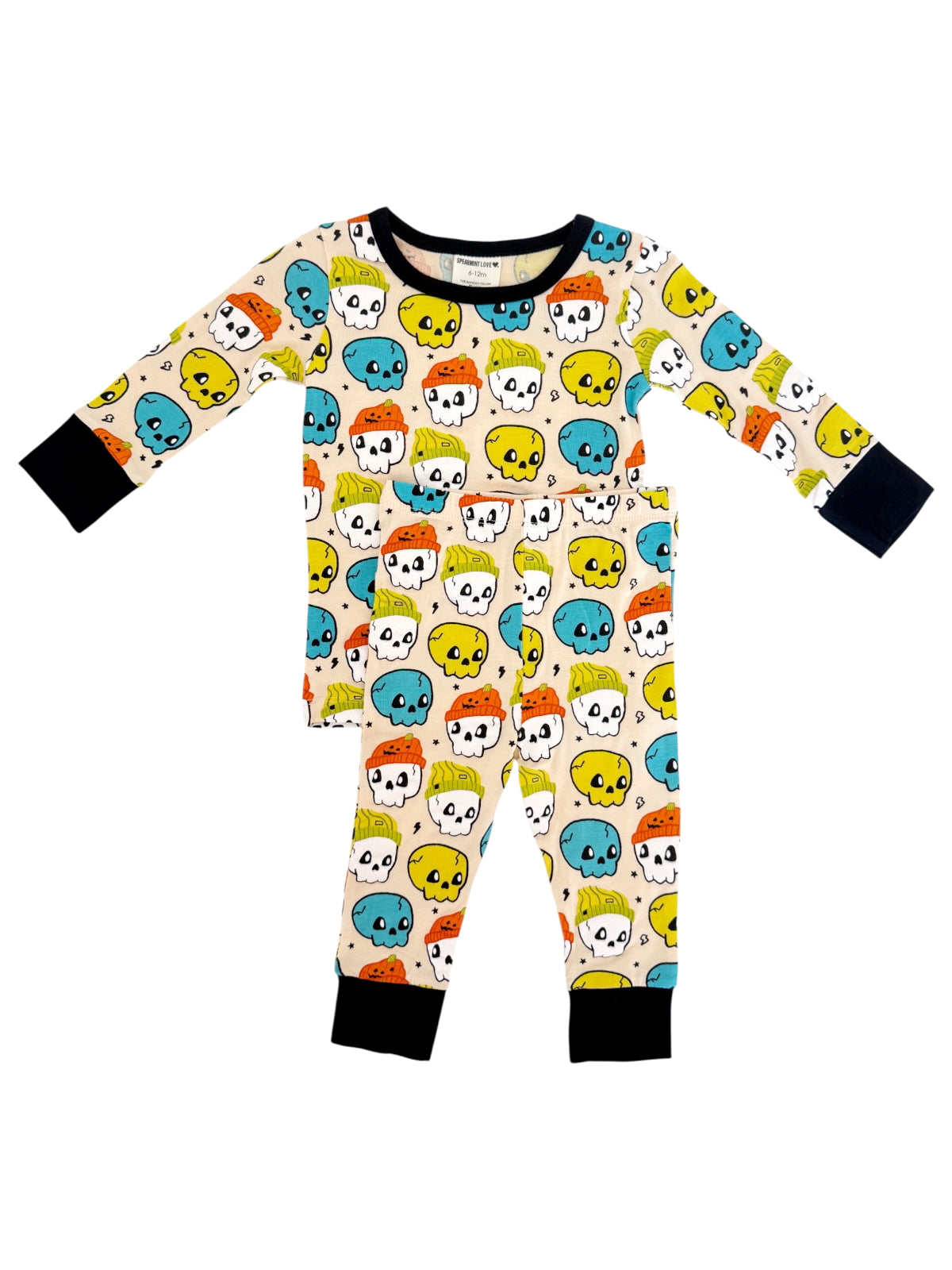 Kids' pajamas featuring colorful skulls in blue, orange, yellow, and green on a cream background.