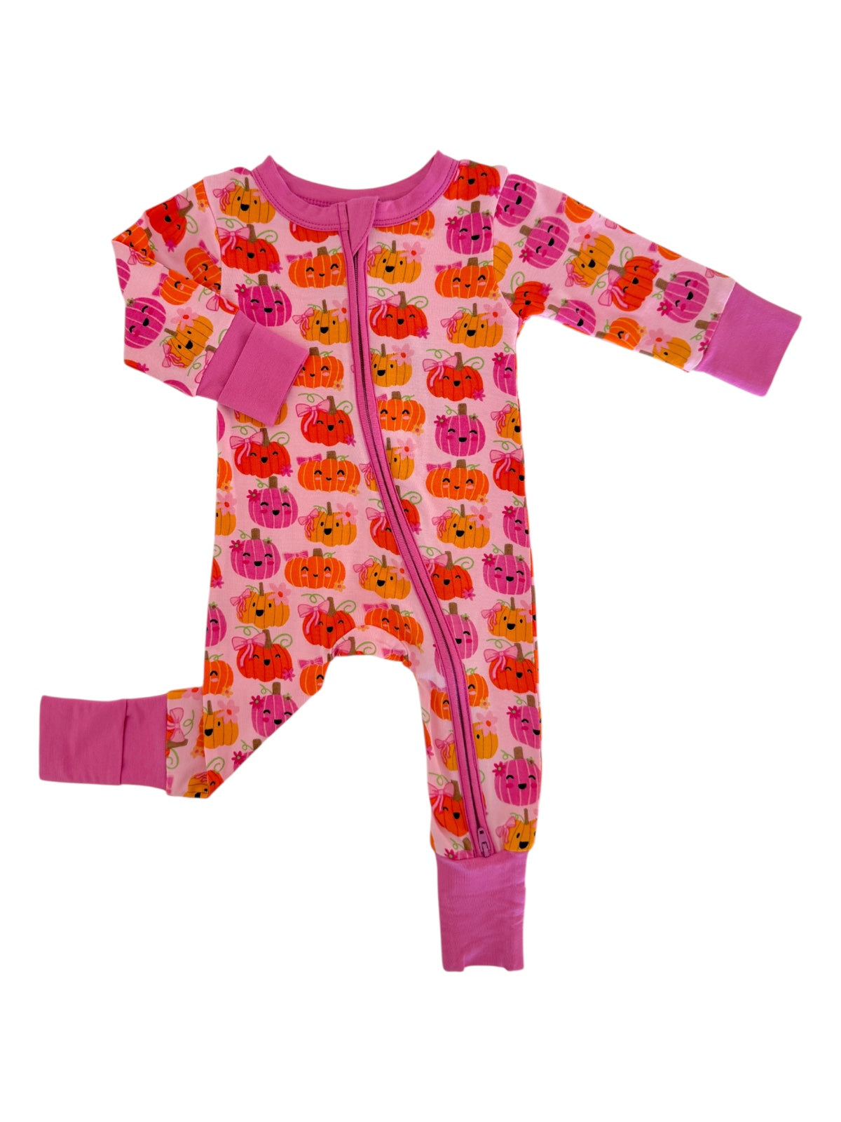Pink pajama onesie with colorful pumpkin print and zip closure. Ideal for toddlers and cozy autumn wear.