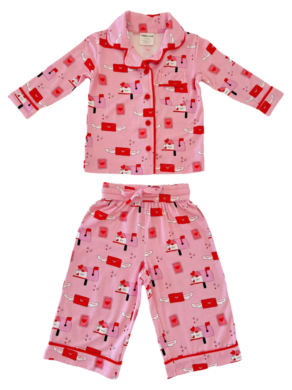 Pink pajama set for kids featuring envelopes and hearts, with a button-up shirt and matching pants.