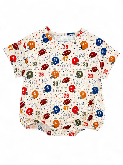Cream shirt with colorful football and star patterns, featuring numbers and helmets for a playful sports theme.