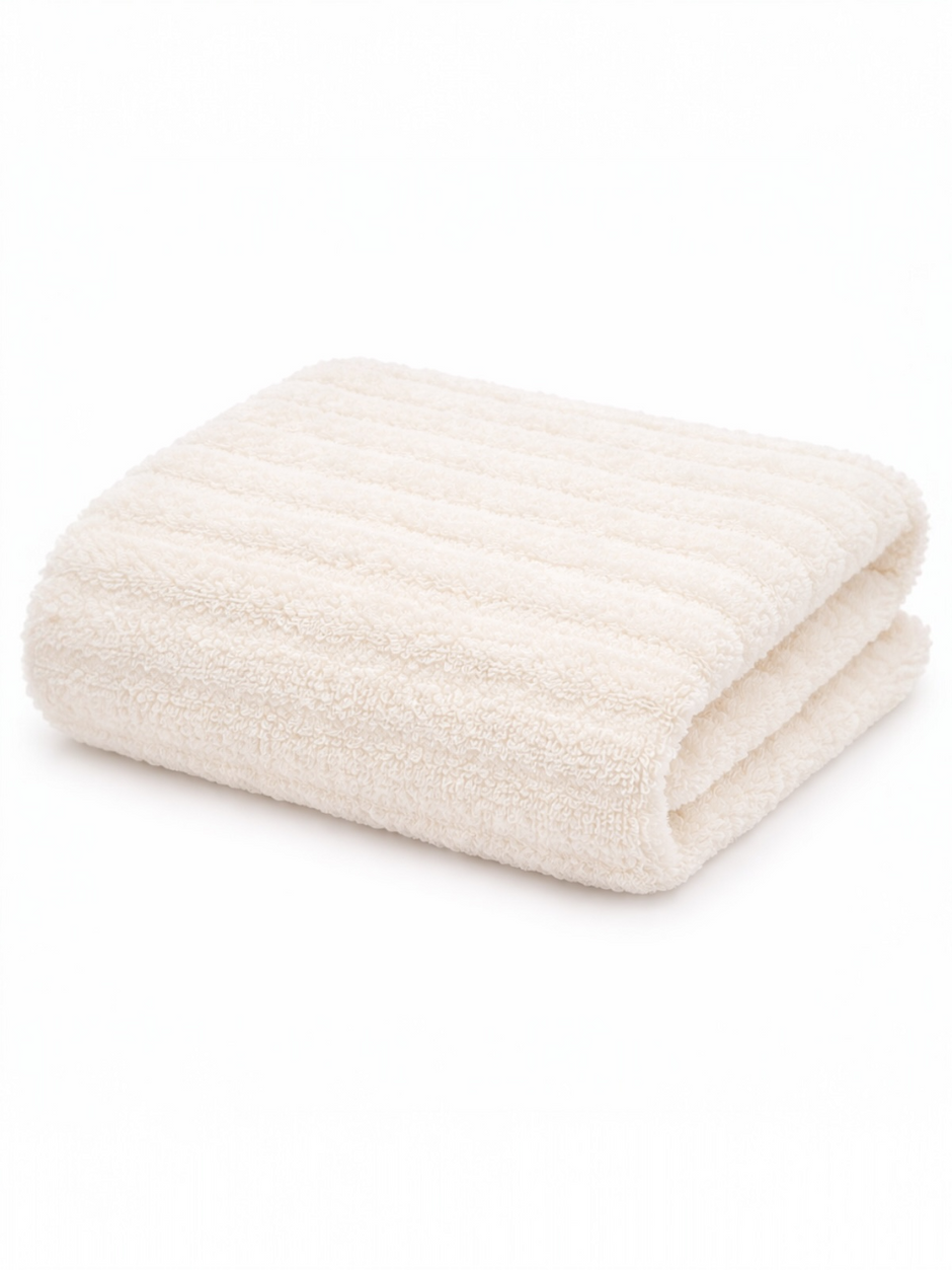 Folded cream-colored towel with a textured surface on a white background.