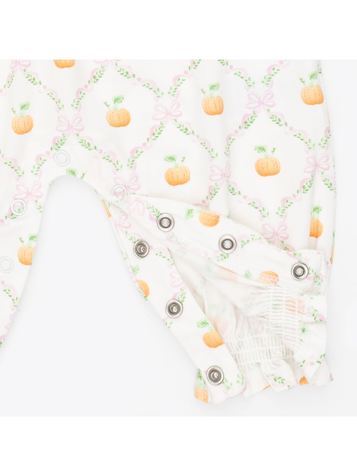 White fabric romper with pink bows and orange pumpkin prints, featuring snap closures at the bottom.