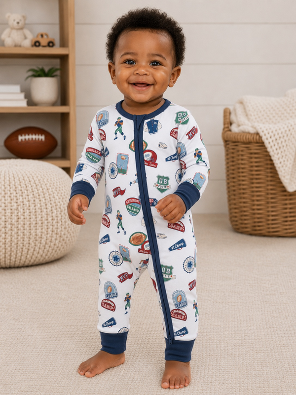 Smiling toddler in football-themed pajamas, standing on a carpeted floor, with toys and decor in the background.