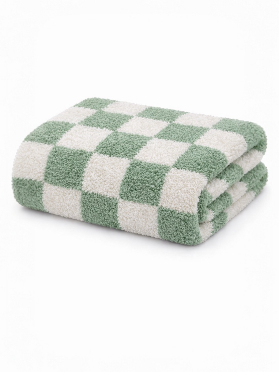 Folding green and white checkered towel stacked neatly on a white background.