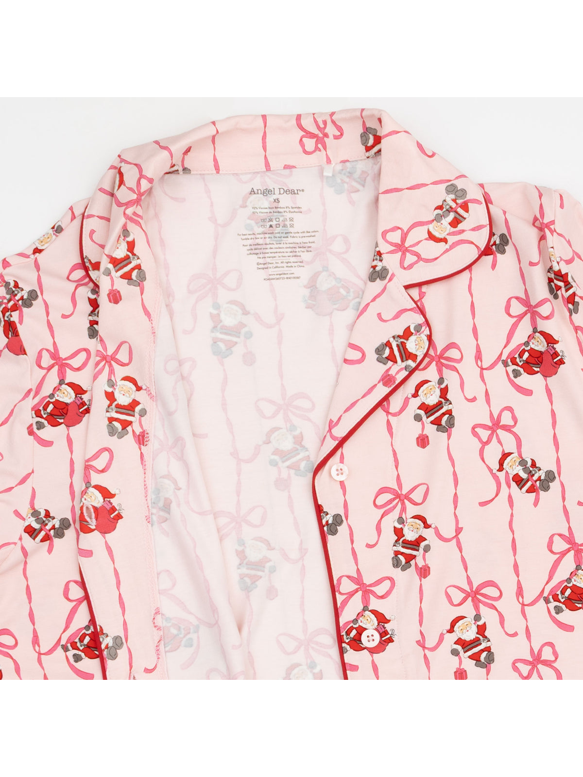 Pink pajama top with Santa and teddy bear prints, featuring red ribbon patterns and a collar.
