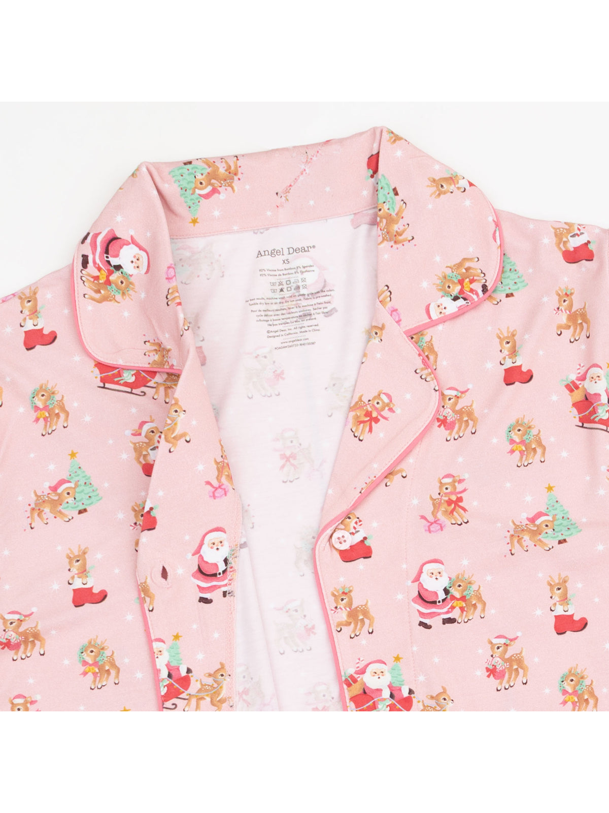 Pink pajama set featuring Santa, reindeer, and Christmas trees in a cheerful, festive print.
