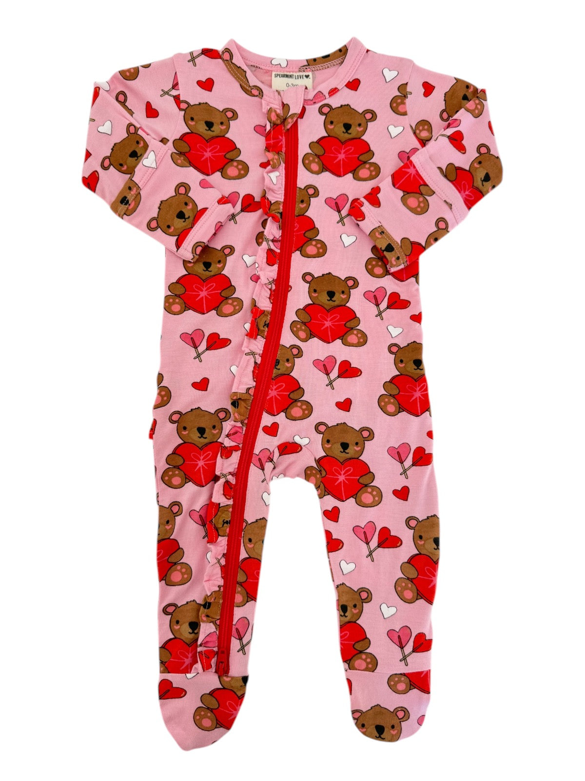 Pink onesie with teddy bears holding hearts, featuring a front zipper and ruffled detailing. Perfect for infants.