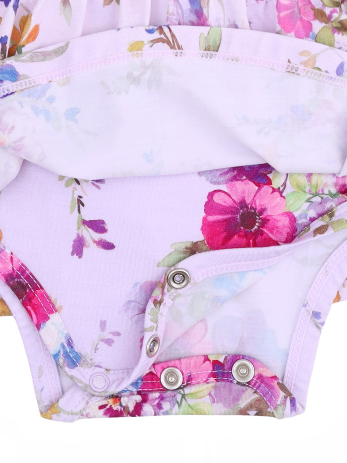 Floral-patterned baby onesie with snap closure at the bottom, featuring shades of purple, pink, and green.