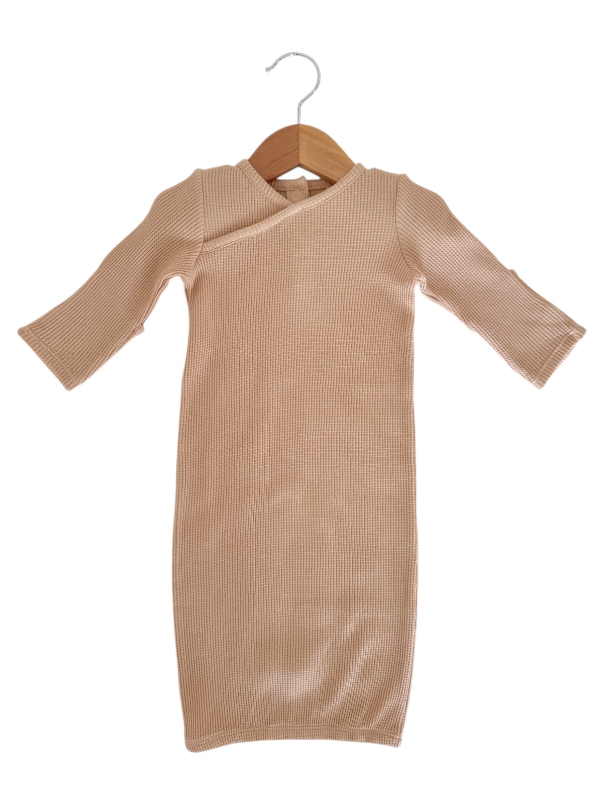 Beige ribbed dress with a crossover neckline, hanging on a wooden hanger against a white background.