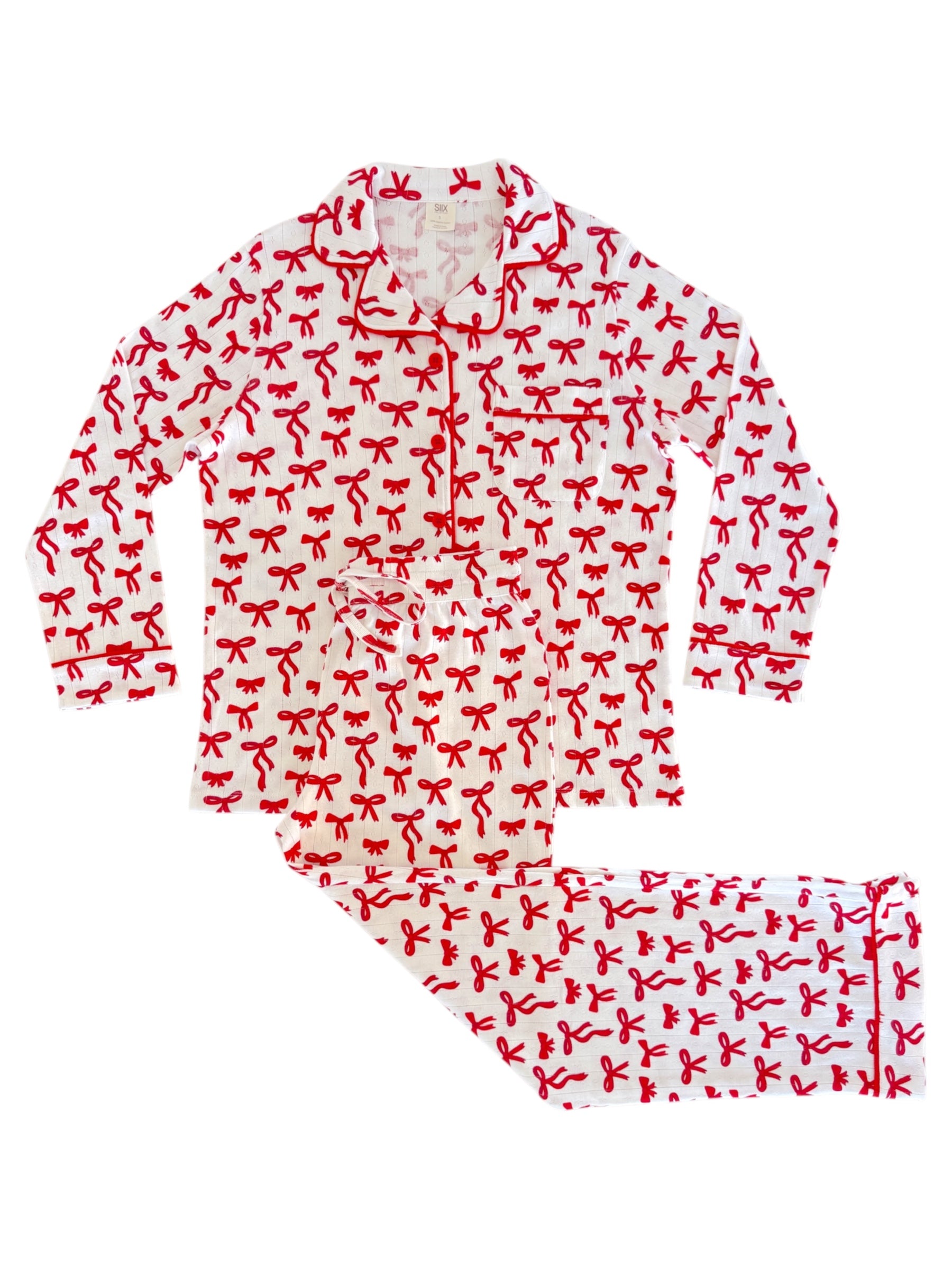 Red and white pajama set featuring a festive bow pattern, including a long-sleeve top and matching pants.