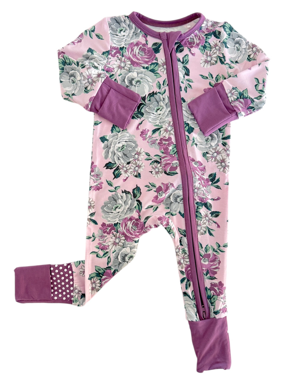 Floral-patterned pink baby onesie with purple cuffs and zipper front.